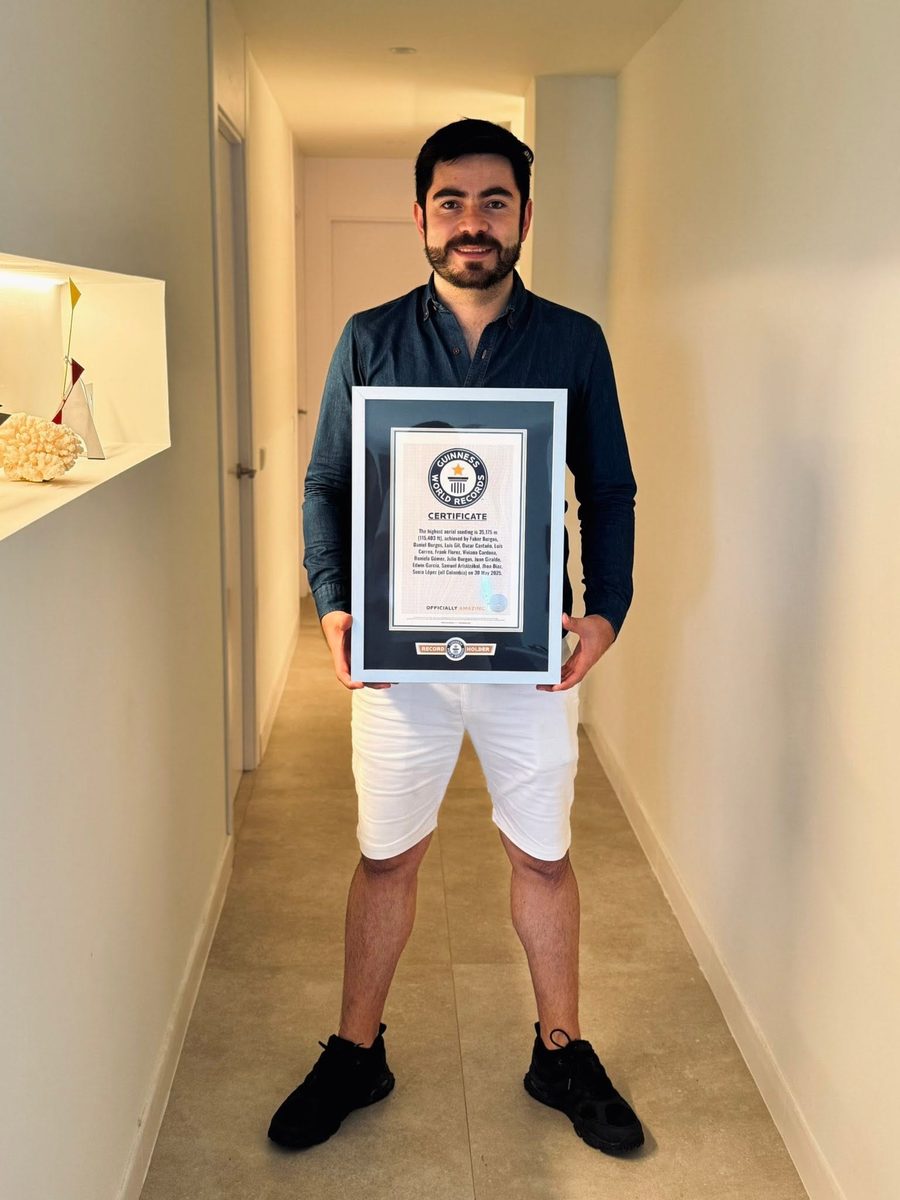 Oscar Castaño Chavez sosteniendo el certificado del Récord Guinness de mayor altitud en una siembra aérea: 35.175 metros, 30 de mayo de 2025